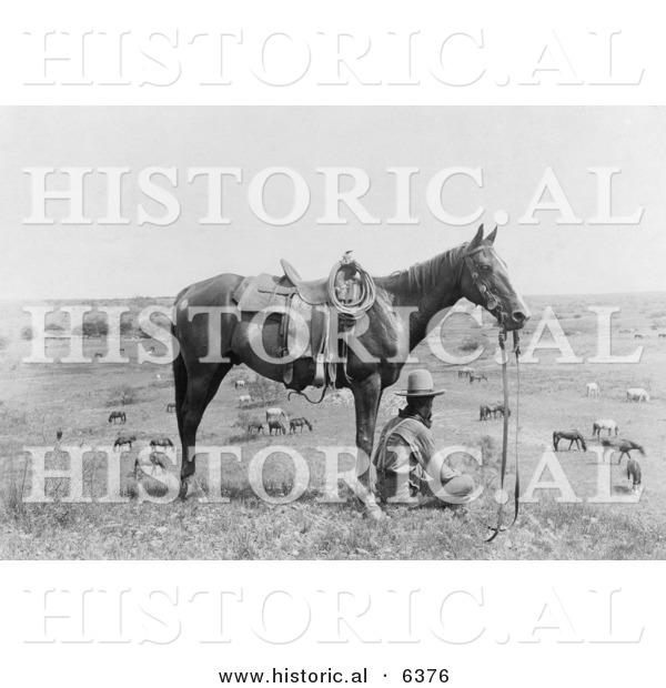 Historical Photo of a Cowboy Sitting Beside His Saddled Horse on a Hill, Overlooking Horses in Bonham, Texas, 1910 - Black and White Version