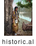 Historical Photo of Young Native American Indian Girl Posing Against a Tree Beside a Boat on a River Bank 1904 by JVPD